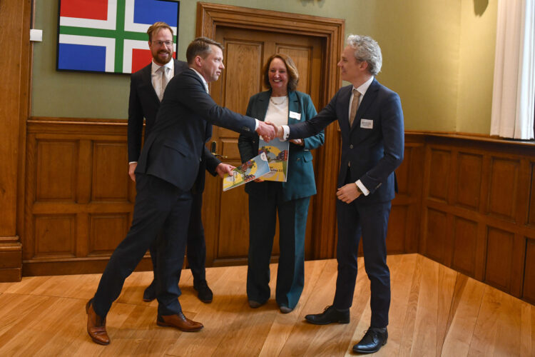 Gedeputeerde Pascal Roemers (provincie Groningen) schudt Jacos van Zelst, directeur realisatie woningbouw (ministerie van VRO) de hand, wethouder Rik van Niejenhuis (gemeente Groningen) en Liesbeth Spies (voorzitter Aedes).